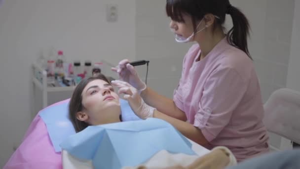 Cosmetologul aplică machiaj permanent pe sprâncene tinere Secvență video de stoc fără drepturi de autor