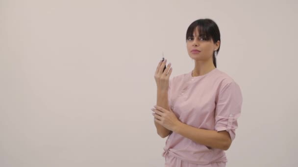 Cosmetologul în uniformă prezintă mașina de tatuat contemporană Videoclip de stoc