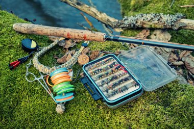 Nehir kıyısında uçan kutu ve olta. Uç balık ve tenkara..