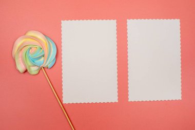 Boş beyaz kartpostal ve pembe arka planda bir çubukta gökkuşağı kreması. Noel, Yeni Yıl, Sevgililer Günü, Uluslararası Kadınlar Günü veya Anneler Günü kompozisyonu. Kopyalama alanı olan düz.