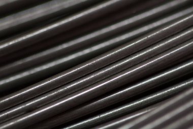 Yapım atölyesinde ya da inşaat alanında paslanmaz çelik tel. Bahar üretimi ya da beton takviyesi için tel rulo yakın çekim. Metal doku. Sanayi veya inşaat konsepti.