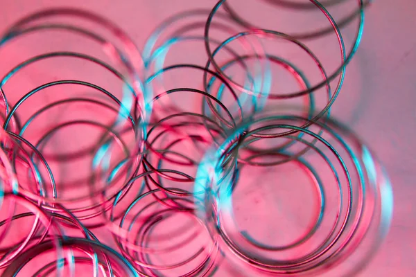 Production of independent springs for mattresses. Independent spring blocks on pink background. Coiling and hardening of springs. Furniture manufacture. Industrial and business concept.
