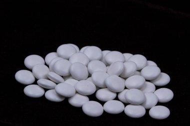 Siyah arka planda beyaz haplar. Konu makro fotoğrafçılık.