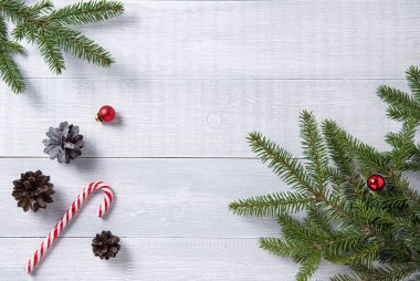 Noel ağacı, koniler, şekerler ve oyuncaklar tahta arka planda yatıyordu. Resim üst görünümü ve boşluk kopyala
