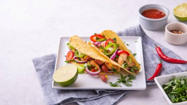 İki Meksika tacosu, tavuk, soğan, biber, mısır ve fasulye servis tabağında limon ve baharatla. Düz yat ve boşluğu kopyala