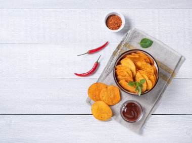 Kırmızı biberli Meksika cipsi ve beyaz ahşap arka planda barbekü sosu. Üst görünüm ve kopyalama alanı