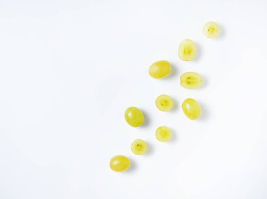 Beyaz arka planda yeşil üzümlerden yapılmış yaratıcı düz bir yatak. Üst görünüm ve boşluk kopyala. Yiyecek konsepti.