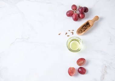 Düz, beyaz mermer zemin üzerinde doğal üzüm tohumu yağından yapılmıştır. Doğal kozmetik, sağlıklı yaşam tarzı. Üst görünüm ve kopyalama alanı