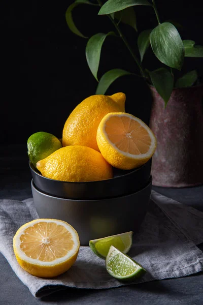 多汁的柠檬和荔枝在灰色桌子上的一个黑色碗里 黑暗和情绪的概念 — 图库照片