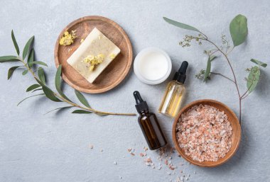 Doğal kozmetik ürünleriyle doğal sabun, yağ ve mineral tuzu soyan konsept güzellik merkezi. mavi arka planda. En üst görüntü