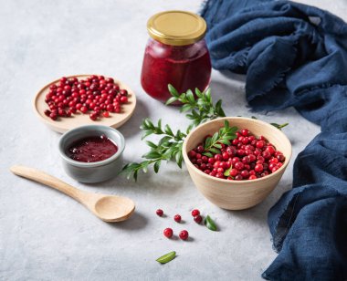 Mavi peçete ve kavanoz reçelli ahşap bir kasede el yapımı reçelli sulu orman yaban mersini. Ev yapımı sağlıklı yemekleri hesaba katın. Resmi kapat