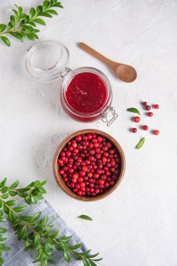 Ev yapımı yaban mersini reçeli ile bembeyaz masada mavi peçeteli inek üzümü konsepti. En üst görüntü