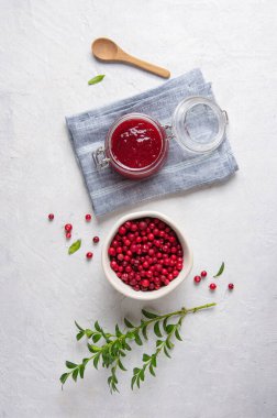 Ev yapımı yaban mersini reçeli ile bembeyaz masada mavi peçeteli inek üzümü konsepti. Üst görünüm ve boşluk resmi kopyala