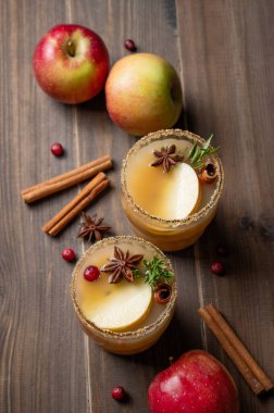 İki bardak tarçın, anason, esmer şeker ve böğürtlen ve meyveli biberiyeli elma şarabı. Sonbahar ve kış için geleneksel, baharatlı, sıcak bir içecek kavramı. Üst görünüm, alanı kopyala.