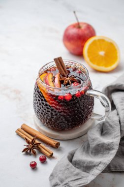 Baharatlı sıcak şarap, portakal ve elma dilimleri, mermer zemin üzerinde meyve ve peçeteyle tarçın çubukları. Geleneksel bir sonbahar ya da şenlikli bir Noel içeceği. Boşluğu kopyala.
