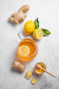Taze limon ve zencefilli, bal, narenciye ve kökle dokulu bir arka planda düz bir bardak sıcak çay. Dokunulmazlığı ve sağlığı arttırmak için doğal içecek kavramı. Üst görünüm, alanı kopyala.
