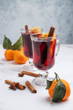 İki bardak sıcak şarap, portakal, tarçın ve mandalinalı mermer zemin üzerinde yıldız anason. Sıcak bir kış içeceği ve sıcak bir ev atmosferi. Ön görünüm, boşluğu kopyala.
