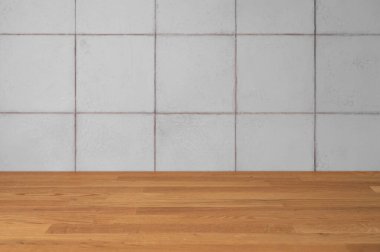 Boş, açık gri fayanslı bir duvar ve doğal ışıkta ahşap bir tezgah. Minimalist, modern bir iç mekan konsepti, afiş veya ürün sergisi için ideal bir zemin. Ön görünüm, boşluğu kopyala.