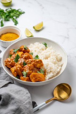 Baharat, kaşık ve peçeteli mermer zemin üzerinde Basmati pilavlı Hint yağlı tavuk köri. Geleneksel, otantik doğu yemekleri kavramı. Üst görünüm, alanı kopyala.