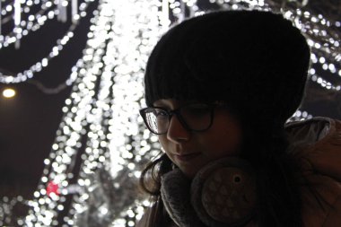 Şehirde seans için poz veren sevimli küçük kız. Noel zamanı