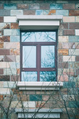 Tuğla duvar ve ağaç şubelere penceresinde bir kış sahne.