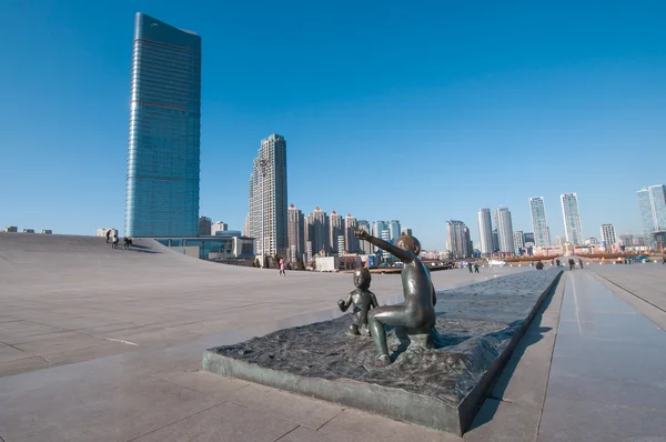 Sculpture of boy and girl in front of Xinghai Square — Stock Photo, Image
