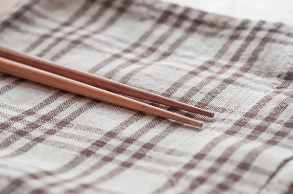 Wooden chopsticks on table cloth — Stock Photo, Image