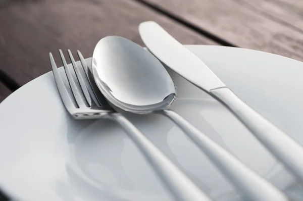 Fork spoon and knife on porcelain dish — Stock Photo, Image