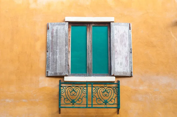 Janela de madeira na casa de parede amarelo saturado . — Fotografia de Stock