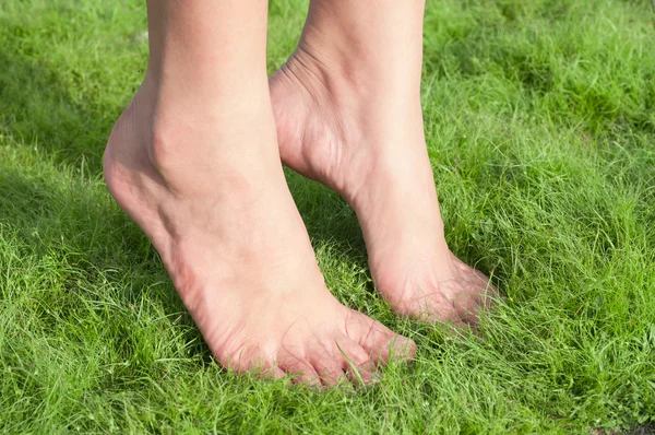 Femme pieds sur herbe verte . — Photo