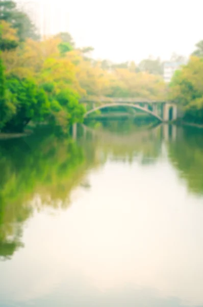 Rozostření pozadí obrázek oblouku kamenný most přes jezero — Stock fotografie