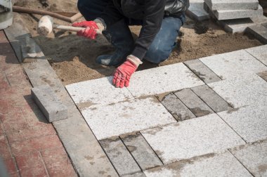 Construction worker installing the pavestone clipart