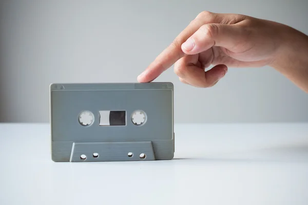 Hand point finger on old retro cassette tape. — Stock Photo, Image