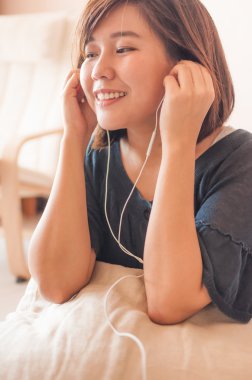 Kadın evde kulaklık ile müzik dinleme.