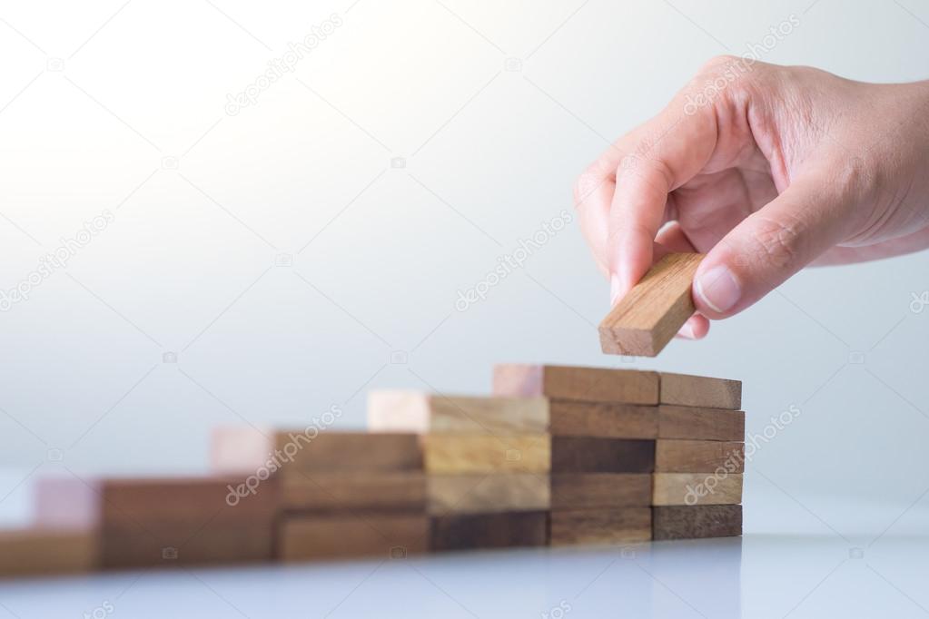 Hand aranging wood block stacking as step stair. 