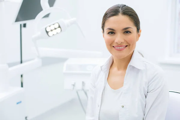 Fiduciosa Donna Caucasica Uniforme Bianca Seduta Uno Studio Dentistico Sorridente — Foto Stock