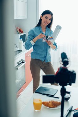 Kağıt rulolarıyla kameraya gülümseyen ve video kaydederken renk örnekleri gösteren güzel bir bayan.