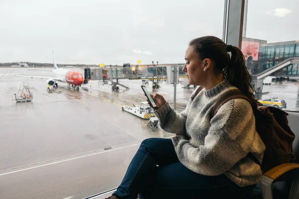 Mulher esperando no aeroporto usando seu smartphone — Fotografia de Stock