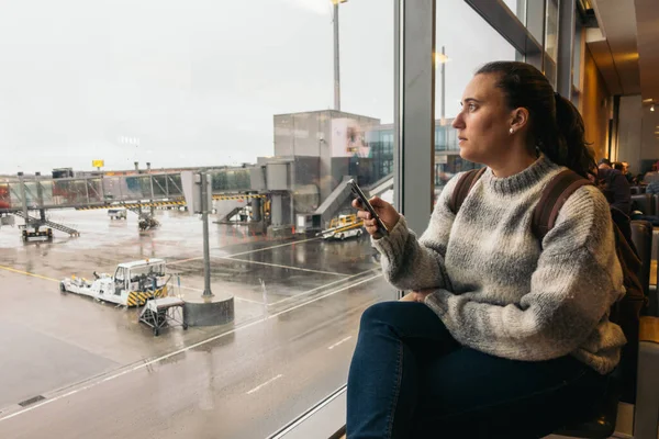 Nueva York, Estados Unidos - 27 de octubre de 2020: mujer esperando en el aeropuerto con su smartphone — Foto de Stock