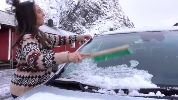 Niña quitando nieve del vidrio del coche en Noruega — Vídeos de Stock