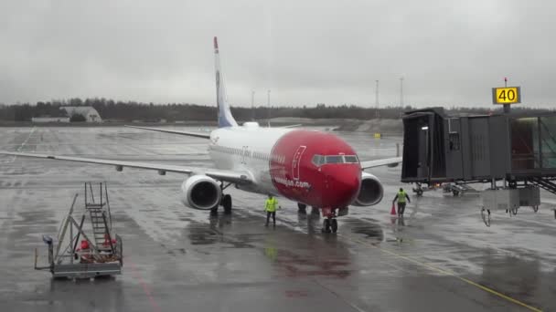 Oslo, Norveç - 05 Ocak 2021: Bir Norveç uçağını kalkışa hazırlamak ve yağmurlu bir günde iskeleyi bağlamak. — Stok video