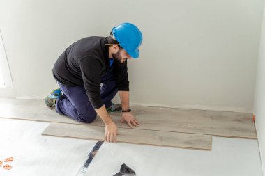 Marangoz, odaya kaplama döşeme kuruyor..