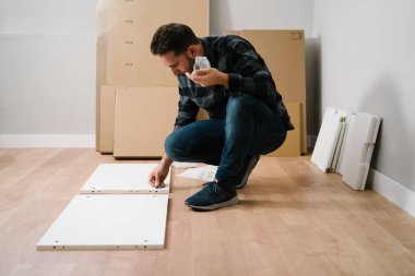 Adam yeni evi için mobilya montajı yapıyor. Mobilya montajını kendin yap..