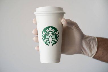 New York, ABD - 15 Mart 2021: Yeniden kullanılabilir bir Starbucks bardağı tutan beyaz eldivenli