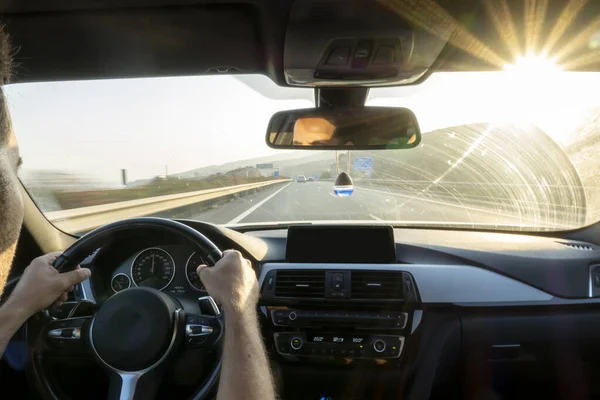 Homem anônimo dirigindo sua luz de fundo do carro na estrada — Fotografia de Stock