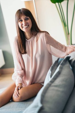 Genç bayan evde dinleniyor, mutlu ve rahat hissediyor.