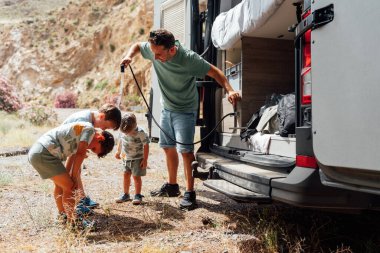 Babası, doğadaki çocukları için bir karavan duşu kullanıyor.