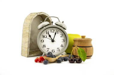 Eski moda çalar saat, elma, bal kavanozu, kiraz, kırmızı frenk üzümü ve yaban mersinli mutfak hayatı.