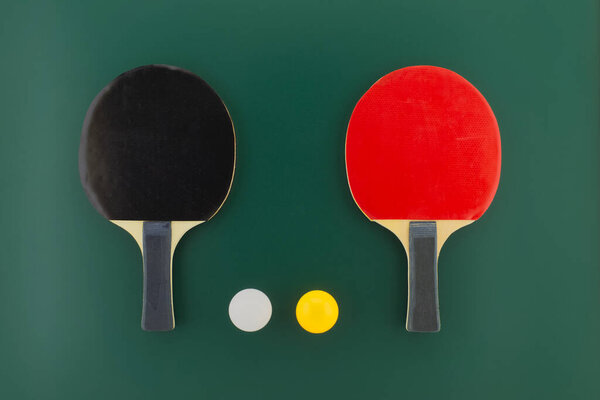 Table tennis equipment, racks and balls on green background with free copy space