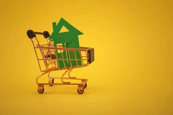 Comprar Concepto Bienes Raíces Con Casa Carrito Compra Fondo Amarillo —  Fotos de Stock